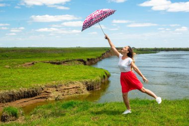Nehir kenarında bir şemsiye üzerinde uçarken