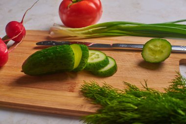 yeşil salatalık kesim tahtasında ve sebzelerde