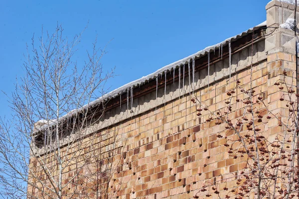 Rampouchy visí ze střechy v zimě — Stock fotografie
