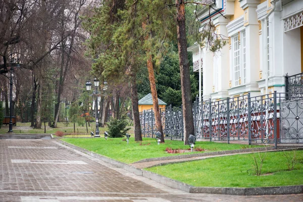 Igreja e calçada molhada da chuva no parque da cidade na primavera — Fotografia de Stock