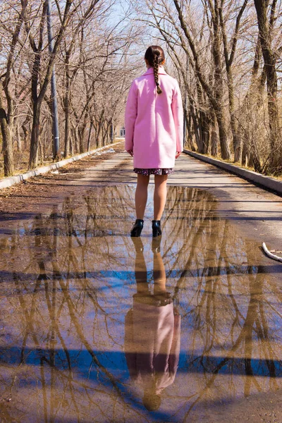 Reflection of a girl in a huge puddle on an alley with trees — Stock Photo, Image