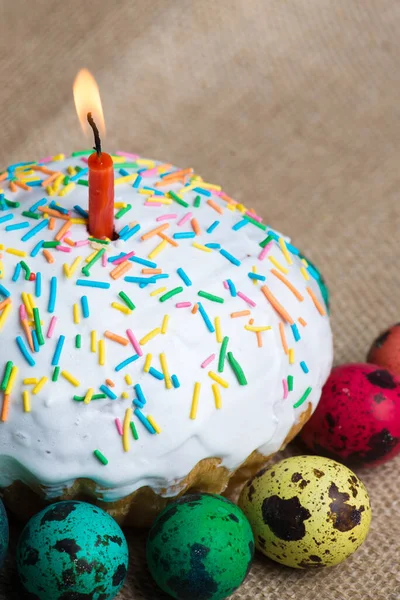 Un pastel con glaseado y rociado y una vela — Foto de Stock