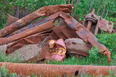 Bir avuç paslı boru çimlerin üzerinde yatıyor.
