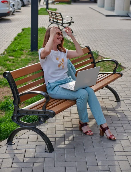 Emotions of a woman on a bench with a laptop — Stock Photo, Image