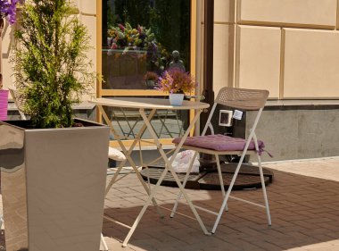 Kafenin yanında duran sandalyeli güzel bir kütük.