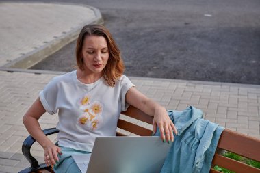 Dizüstü bilgisayarda bankta çalışan bir kız.