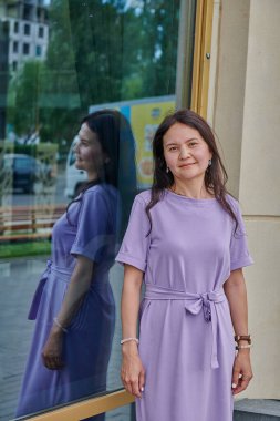 Pencerede elbiseli bir kız var.