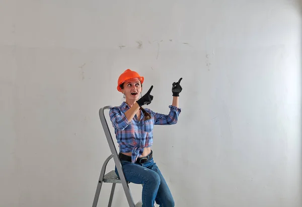 На фоне белой стены строитель в шлеме — стоковое фото