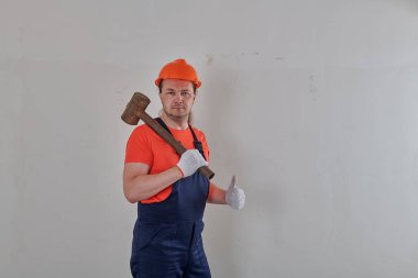 Eldivenli bir müteahhit elinde balyozla