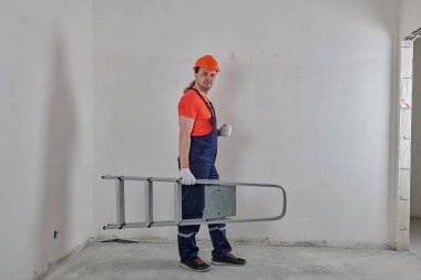 Kızgın mühendis kolunun altında bir merdiven tutuyor.