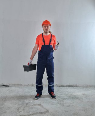 Elinde alet çantası olan bir ustabaşı.