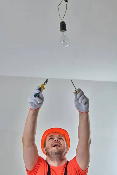 electrician repairing the light in the apartment