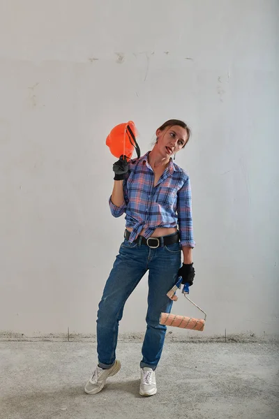 Orangefarbener Helm auf der Reparaturfrau in Jeans — Stockfoto