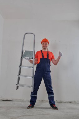 Profesyonel bir tamirci bir elinde merdiven tutar.