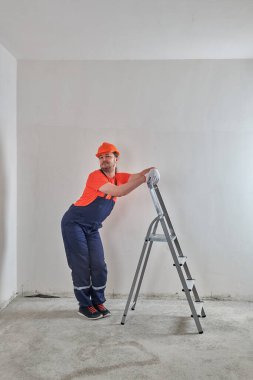 Komik usta merdivende kaskla duruyor.