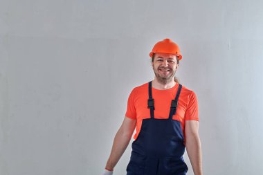 Duvarın arkasında neşeli bir tamirci duruyor.