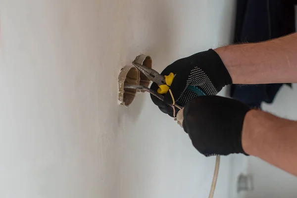 One electrician installs the light in the apartment where the repair — стоковое фото