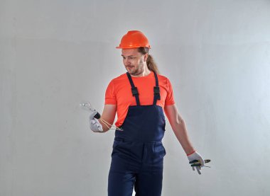 Aletleri olan elektrikçi dairedeki ışığı tamir ediyor.