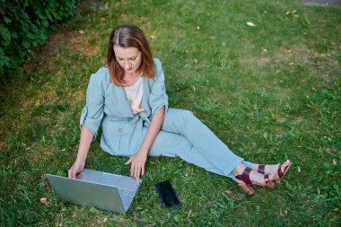 Yeşil elbiseli bir kız gaz pedalında oturuyor.