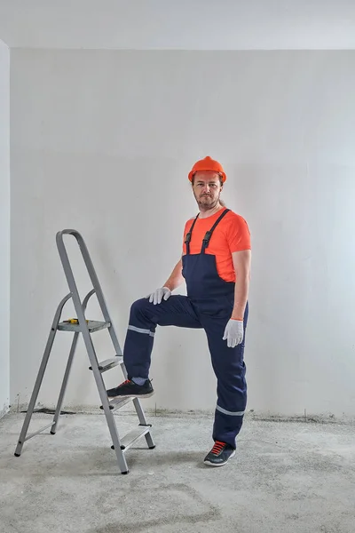 Ремонтник в шлеме поставил ногу на лестницу — стоковое фото