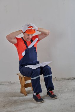 bir elektrikçi projenin çizimlerini dikkatle inceler