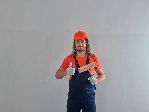 В оранжевом шлеме профессиональный художник в квартире — стоковое фото