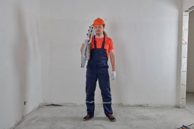 Uzun saçlı neşeli mühendis elinde merdiven tutuyordu.