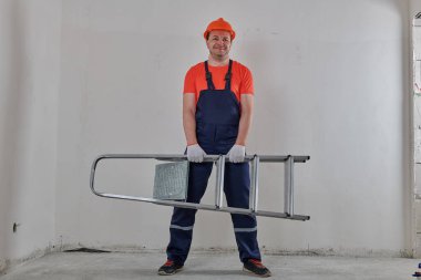 Önünde merdiven tutan güçlü bir adam.