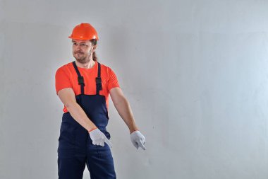 Mavi tulumlu, akıllı bir işçi ayakta durur.