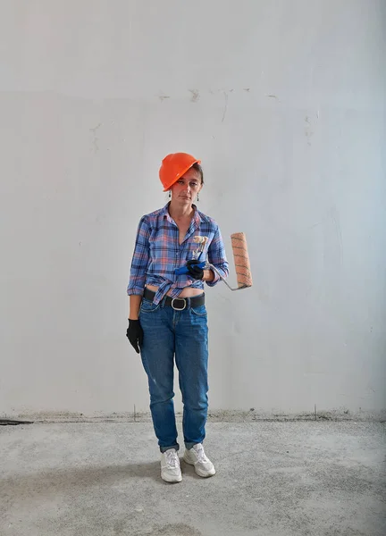 Pintor cansado em capacete laranja e rolo — Fotografia de Stock