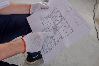 İşçi, yenileme amaçlı bir daire planına işaret eder