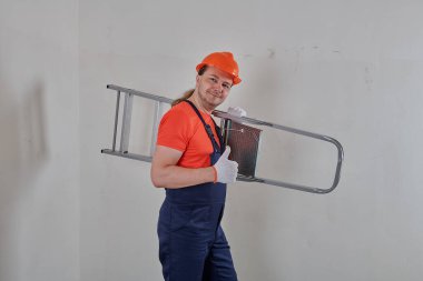 Turuncu kask takan bir mühendis merdiven tutar.