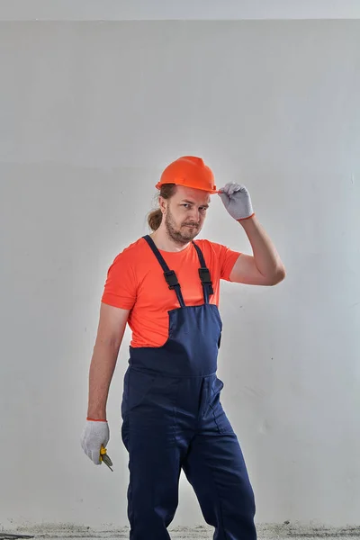 Un homme dans un appartement rénové en salopette lumineuse — Photo