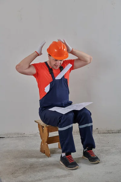 Un ingeniero muy estúpido examina los planos del proyecto —  Fotos de Stock