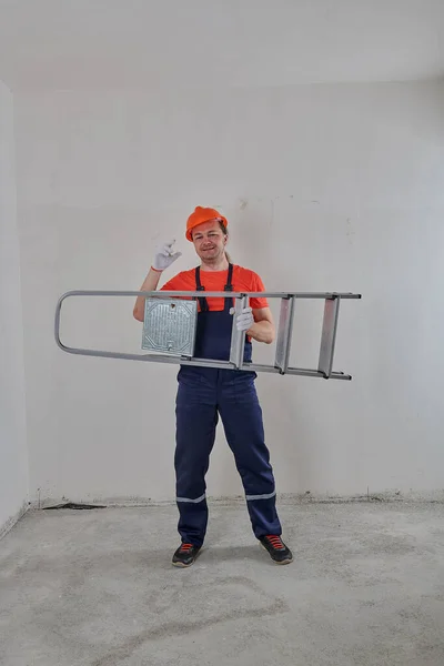 Reparador bombeado sostiene una escalera sobre su cabeza —  Fotos de Stock