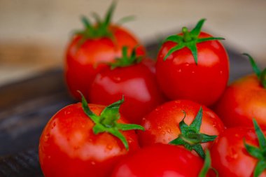 Ahşap arka planda kırmızı domatesler uzanır.