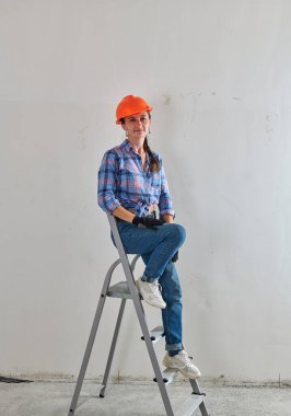 Ekose gömlekli bir kız merdivende oturuyor.