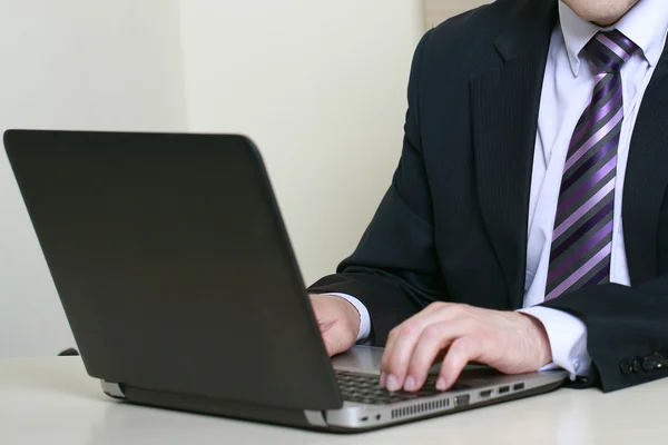 Ofiste dizüstü bilgisayar kullanan bir iş adamı