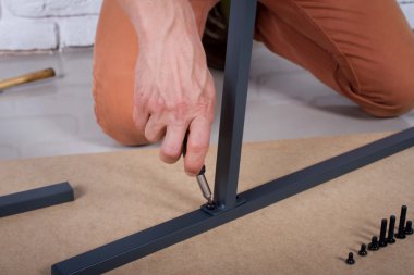 Closeup photo of handyman tightening the screws clipart