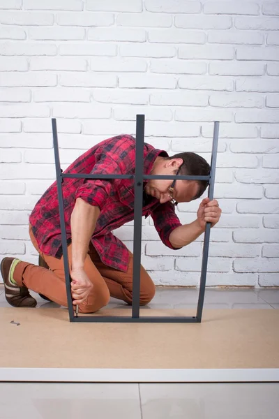 Young man confused about assembling furniture