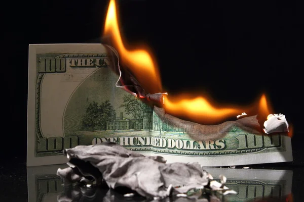 Dollar im Feuer, brennender Dollar, Asche. Krise lizenzfreie Stockbilder