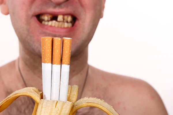 Cigarros em uma banana, fumante, dentes ruins — Fotografia de Stock