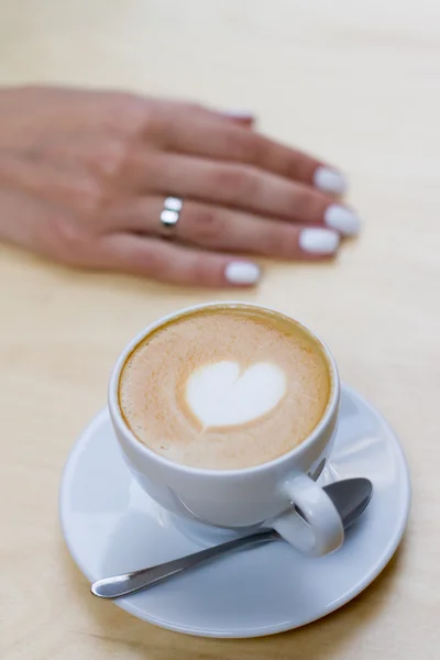 Cappuccino oder Latte Coffee mit Herzform. Braut und Bräutigam trinken am Date eine Tasse Kaffee Latte. glückliche junge Braut und Bräutigam trinken eine Tasse Kaffee Latte mit Herz-Design an ihrem Hochzeitstag Stockbild