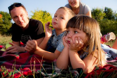 Mutlu bir genç aile yaz günü dışarıda vakit geçirir.
