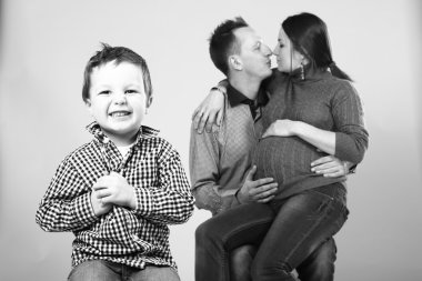 Küçük bir çocuk ve ailesi öpüşme. hamile kadın. Aile mutlu