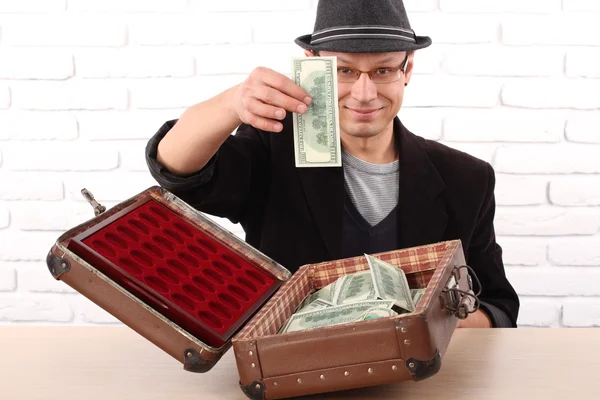 Emotional man in glasses holding bundles of money — Stock Photo, Image