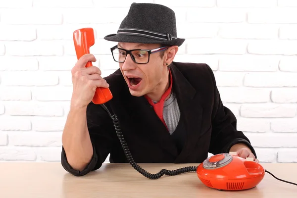 Junger Mann spricht an einem alten Telefon, schöne Emotion lizenzfreie Stockbilder