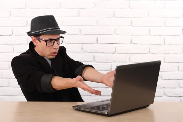 Schockierter junger Geschäftsmann, der mit seinem Laptop auf den Computerbildschirm blickt und fassungslos vor dem Büro des Unternehmens sitzt. Gesichtsausdruck, Emotion, Gefühl, Wahrnehmung, Körpersprache, Reaktion — Stockfoto