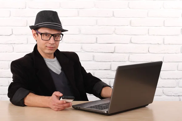 Lycklig man använder smartphone och laptop dator. — Stockfoto