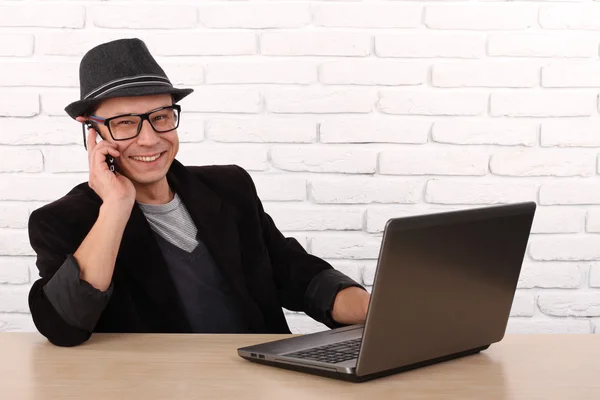 Lycklig man använder smartphone och laptop dator. — Stockfoto